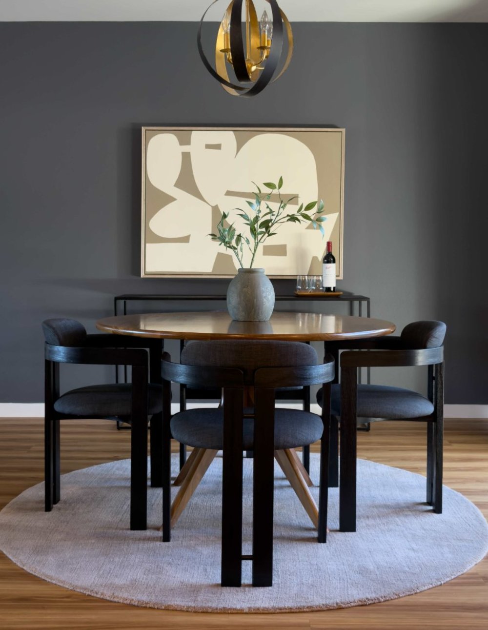 Staged dining room with round table, brass chandelier and abstract artwork, San Carlos