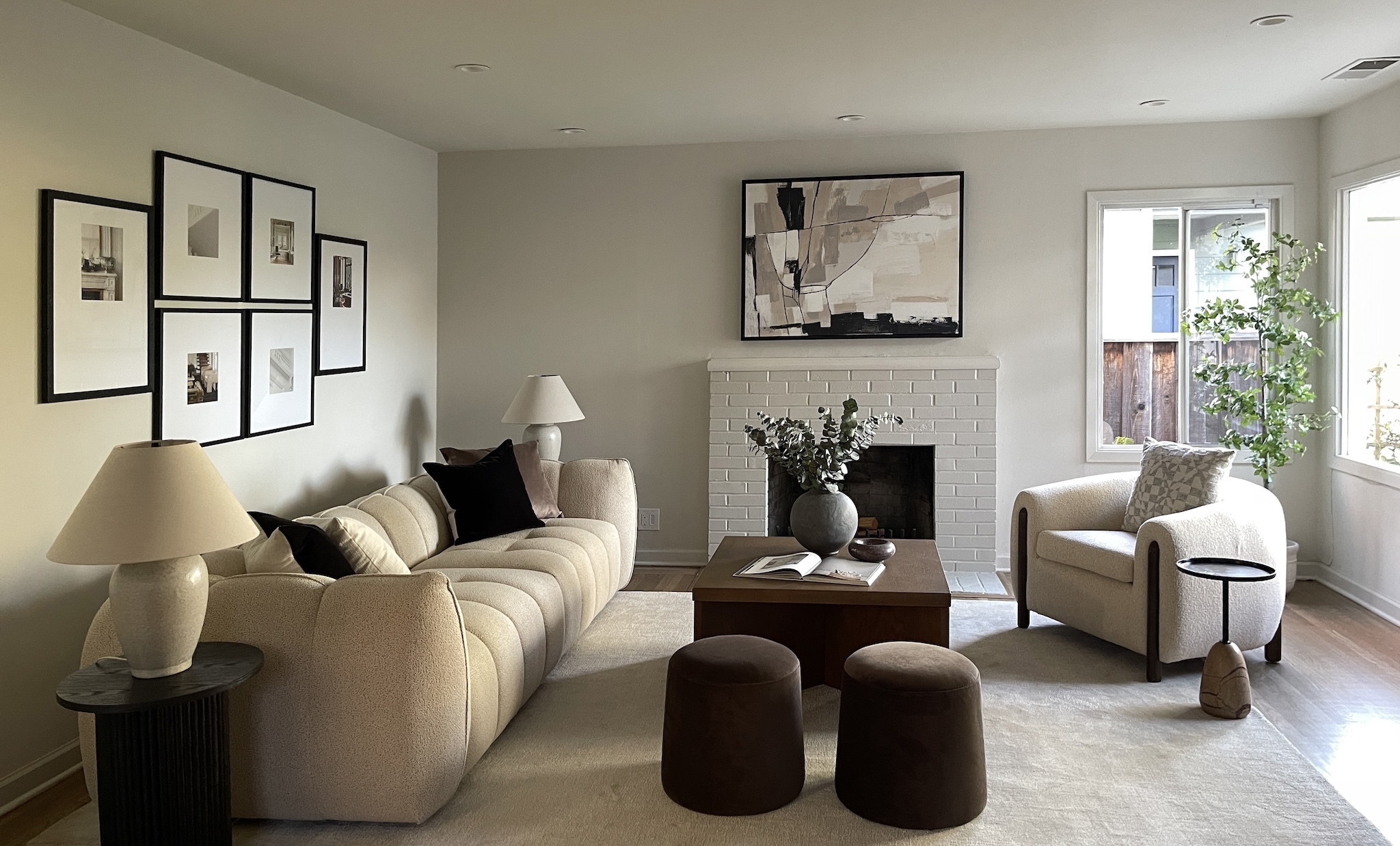 Living room with cream sofa, gallery wall and white brick fireplace