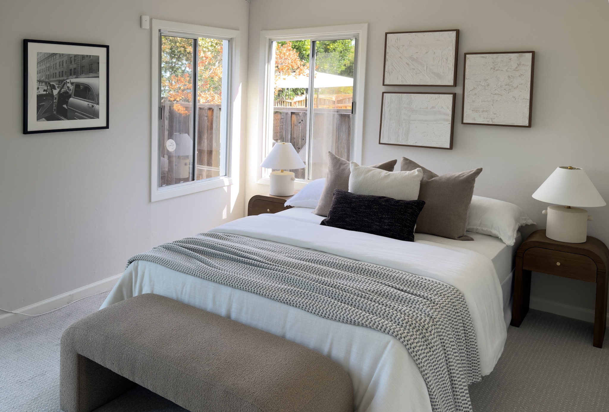 Bedroom with upholstered bench and paired lamps