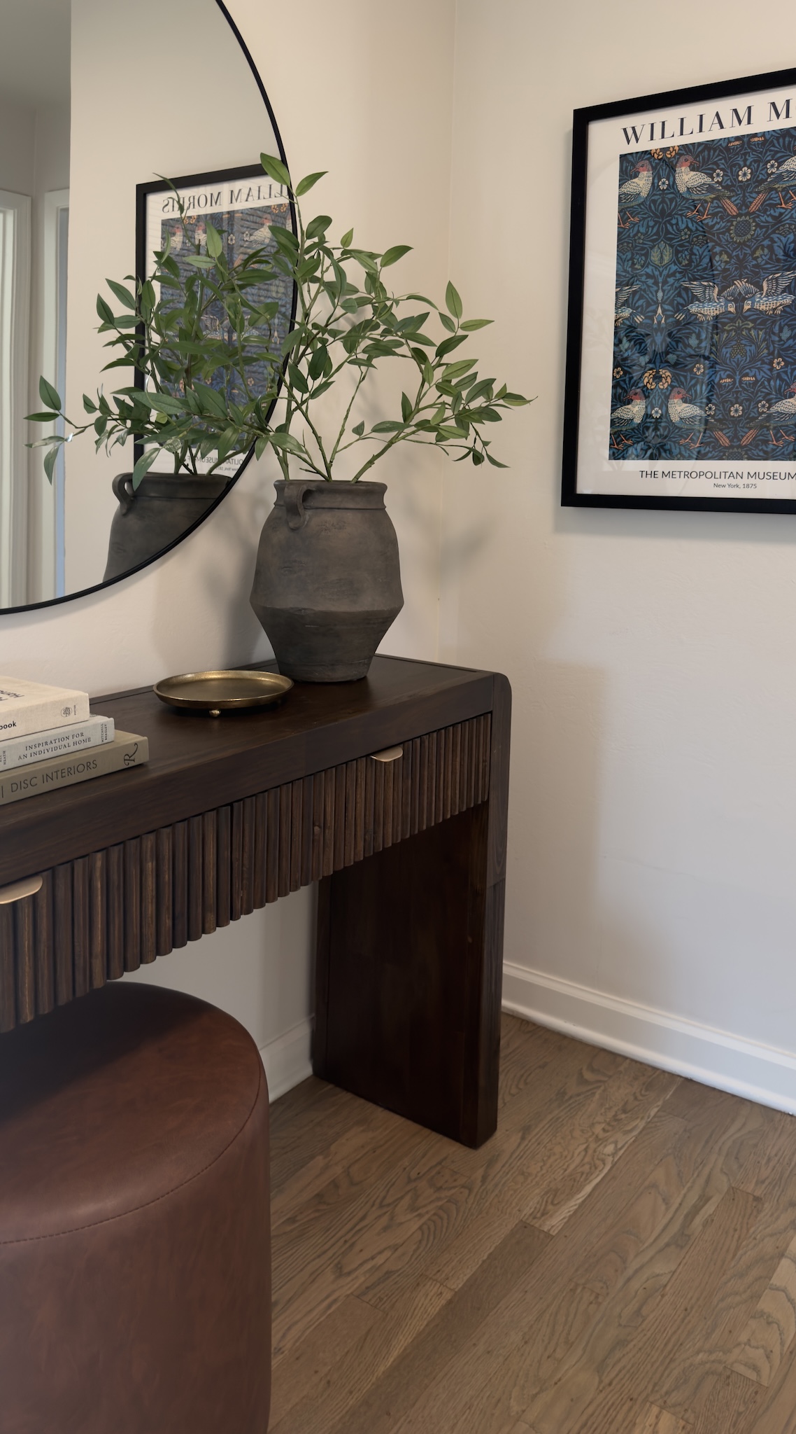 Vanity nook with round mirror, wood console and olive branches
