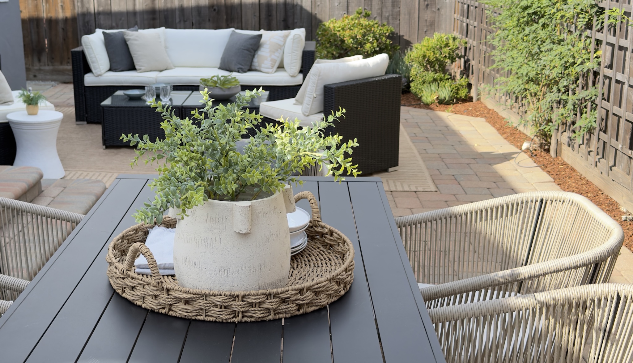 Patio dining table with planter centerpiece and woven chairs