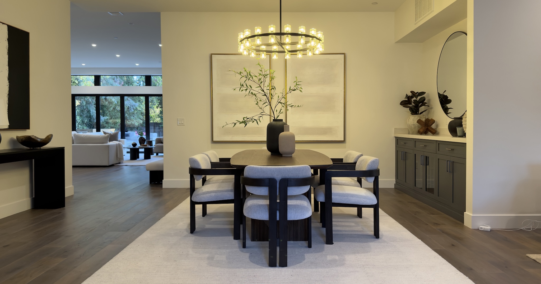 Staged dining room with round chandelier and dark wood table